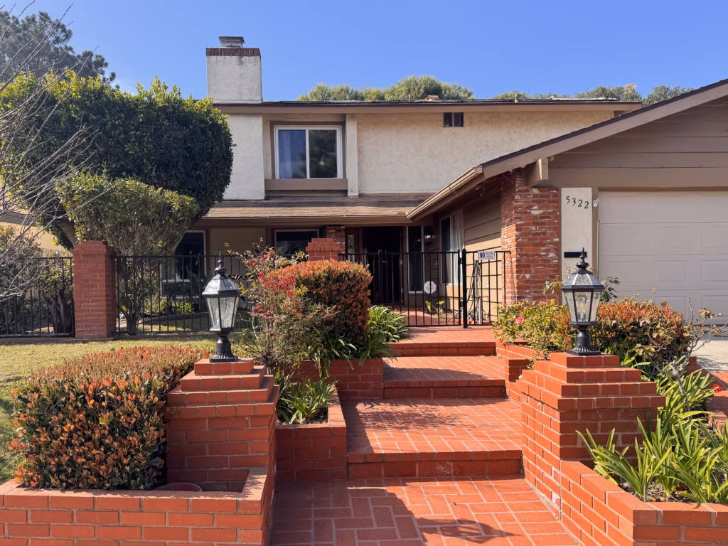 Two-story house with brick steps and garden